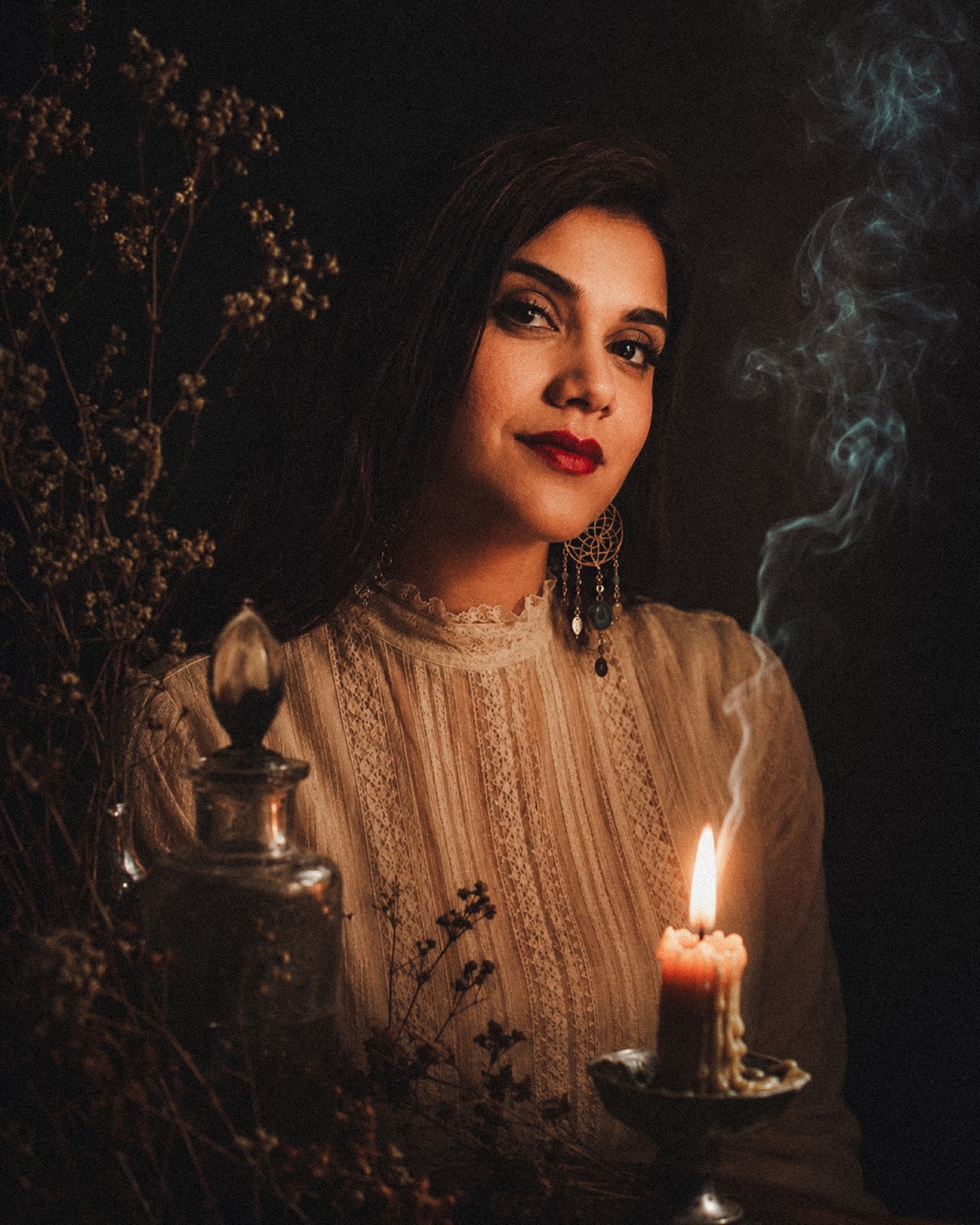 Laura looking toward the camera in a candlelit ritual space